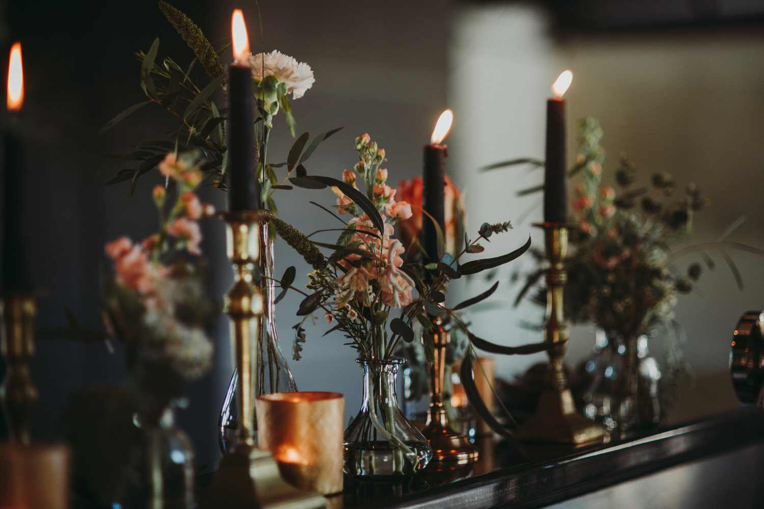black candles and flowers in vases